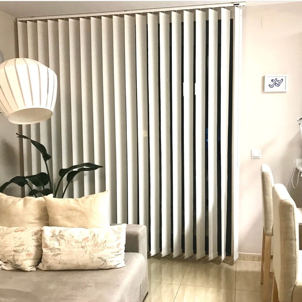 Cortinas verticales y sofá decorativo